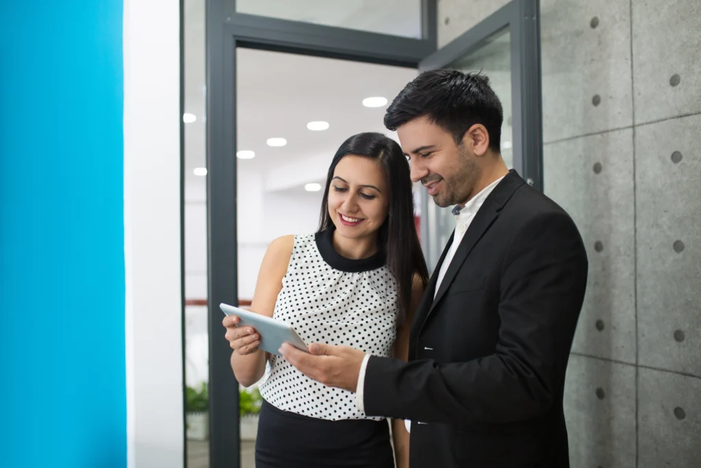portrait cheerful young colleagues browsing digital tablet